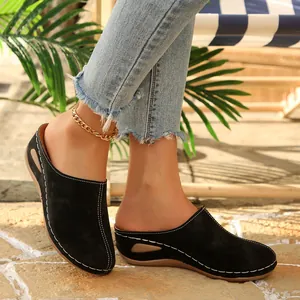Side detail of women's black platform mules with white contrast stitching on model