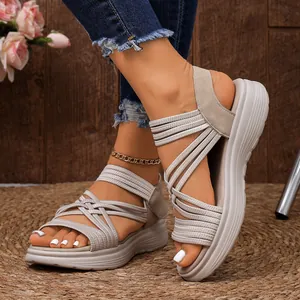 Detailweergave van lichte damessportsandalen met beige elastische gekruiste bandjes.