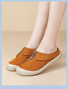 Detail of brown suede women's slip-on shoes with stylish front zipper and thick sole