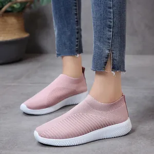 Detail view of pink women's knit mesh slip-on sneakers with white soles.