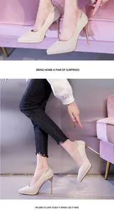 Detailaufnahme champagnerfarbener Glitzer-Stilettos mit Strassketten-Verzierung.