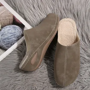 Side and top view of women's taupe wedge mules with warm fleece lining on a grey rug