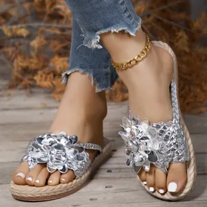 Detail van zilveren dames sandalen met plateauzool en grote metalen bloemversiering