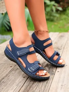 Detail van blauwe platte gladiator sandalen met klittenband en geborduurde sterren.