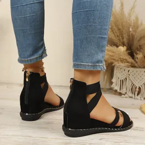 Macro view of black Roman sandals featuring elastic cross straps and rear zipper detail.
