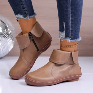 Detailaufnahme brauner Lederstiefeletten mit seitlichem Reißverschluss und Umschlag