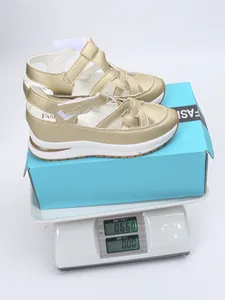 Detailed view of gold platform wedge sandals being weighed on a digital scale for accuracy