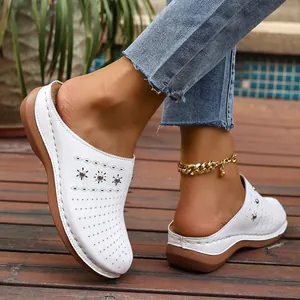 Detail view showing white perforated wedge slippers for women with silver stud accents