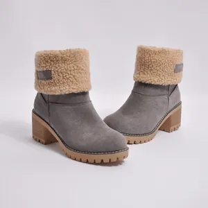 Close-up of gray suede winter boots featuring a foldable beige faux-shearling lining detail.
