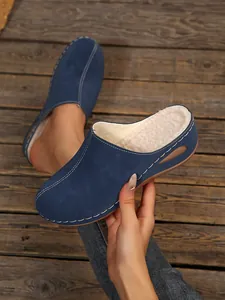 Detail view of navy blue wedge mules with cozy faux fur lining