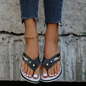 Vue détaillée des tongs à talons compensés noires pour femmes avec décorations métalliques
