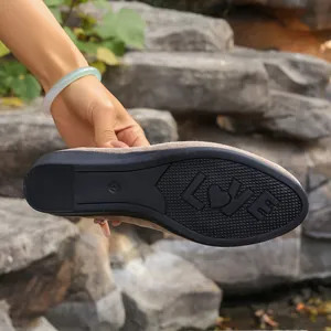 Close-up of the non-slip black sole on a comfortable beige suede women's wedge loafer