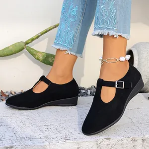Vue détaillée des chaussures compensées rétro en daim noir à bout pointu avec boucle ajustable