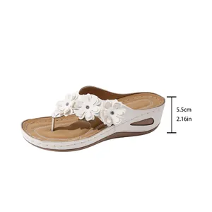 Detailed side view showing the 5.5cm wedge heel height on white floral flip-flop sandals