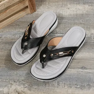 Vue détaillée de tongs compensées élégantes pour femmes avec boucle en métal doré chic.