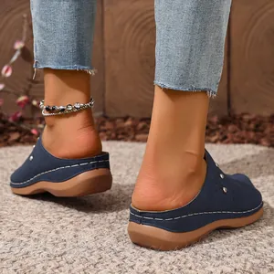 Detailed view of navy blue women's platform mules featuring wedge heel and contrast stitching