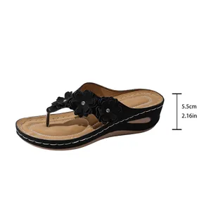 Black wedge flip-flops for women with flower details and 5.5cm heel height measurement