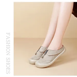 Detailed view of casual beige slip-on shoes with front zipper and platform sole.