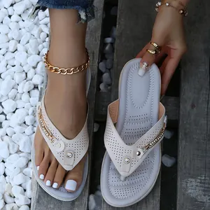 Close-up of beige summer wedge flip-flops featuring elegant metal buckle and rhinestone detail