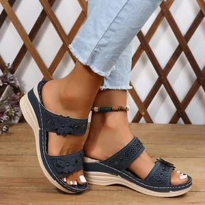 Detail of navy blue wedge sandals with floral appliqués and rhinestone accents