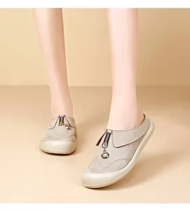 Detail view of stylish beige platform slip-on shoes with decorative zipper ring.