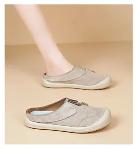 Detail view of beige suede slip-on shoes with zipper on a neutral background