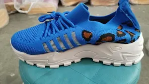 Détail latéral des baskets en maille bleue respirante avec imprimé léopard et semelle blanche