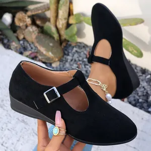 Vue détaillée de ballerines Mary Jane en daim noir avec talon compensé et boucle T-strap