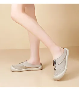 Detail view of casual beige suede mules with front zipper and metal ring detail