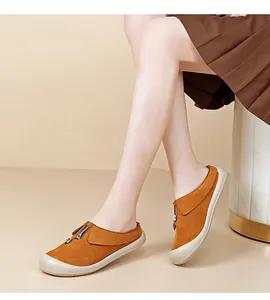 Side view detail of orange suede slip-on shoes featuring a front zipper and thick white sole.