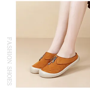 Close-up of stylish brown suede mules with zipper detail and thick sole