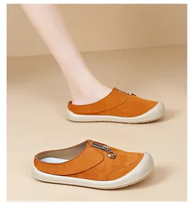 Women's orange suede mules with thick sole and zipper detail in side view detail