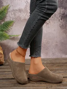 Stylish khaki wedge mules for women featuring closed-toe slip-on design on wooden floor