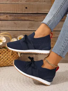 Detailansicht der dunkelblauen Flyknit-Slipper-Sneaker am Model mit Jeans