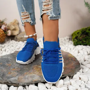 Gros plan de baskets en maille bleue respirante pour femme sur galets