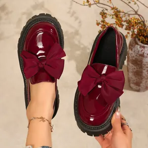 Detailansicht der weinroten Lackleder-Loafer mit großen Schleifen und dicker Profilsohle