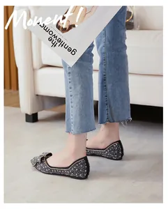 Detailed view of elegant black sequin flat shoes featuring a delicate bow and shallow mouth design