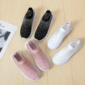 Auswahl an Flyknit-Sneakern mit Strass in Schwarz, Weiß und Rosa auf einem Holzboden