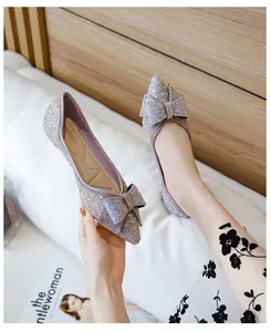 Detailed macro view of elegant sparkly lavender pointed-toe flats with a large bow