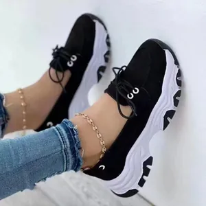 Close-up of women's black platform sneakers with thick white soles and lace-up design