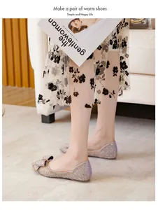 Detailed view of glittery pointed-toe flat shoes with a soft sole and bow accent