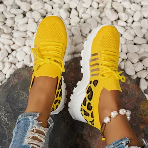 Détail des baskets en mesh jaune respirant pour femmes avec des accents imprimés léopard vifs.