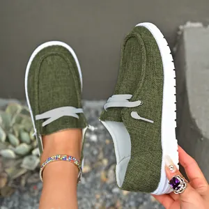 Macro detail of olive green canvas loafers for women featuring casual slip-on design.