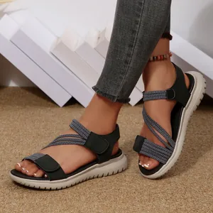 Detail shot of women's black cross-strap sandals with thick white soles and velcro.