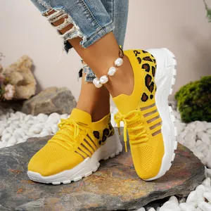Gros plan sur des baskets en maille jaune respirantes avec détails léopard pour femmes