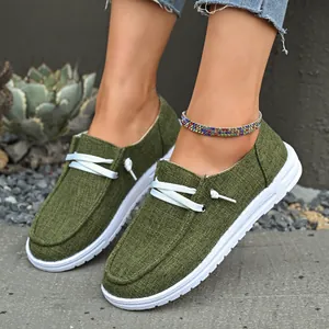 Close-up of stylish olive green canvas loafers with white decorative laces and thick sole