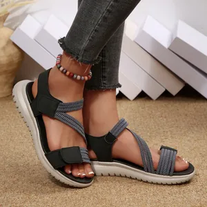 Detail of women's sporty sandals with hook-and-loop straps and thick textured sole.