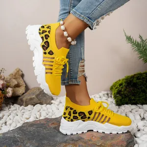 Vue détaillée des baskets en tricot imprimé léopard jaune pour femme avec semelles blanches.