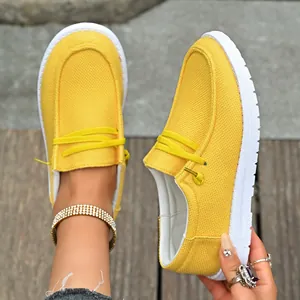 Close-up of vibrant yellow canvas loafers featuring a white sole and casual style