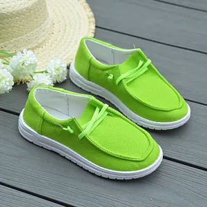 Close-up detail of lime green women's canvas loafers featuring white thick rubber soles